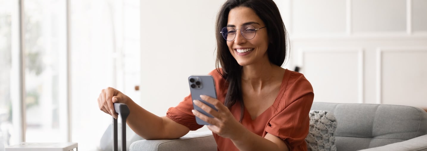 Persona in viaggio con smartphone in mano, sicurezza informatica in vacanza